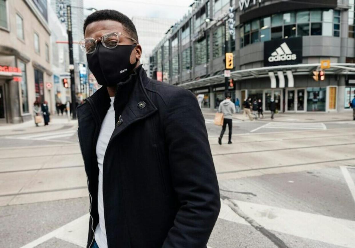 A Torontonian stands at the intersection of Yonge St. and Dundas Ave. Addressing long-standing inequities in immigrant and migrant voter participation in Canada may help shine a spotlight on the social and economic hardships that immigrant and diasporic communities face. That includes health-care access and health outcomes. (Unsplash)