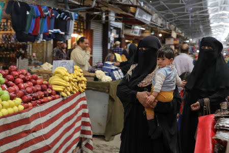 People walks through a market in eastern Mosul, Iraq, April 19, 2017. REUTERS/Marko Djurica