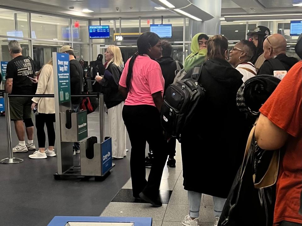 An agent looking at the personal items as people board.