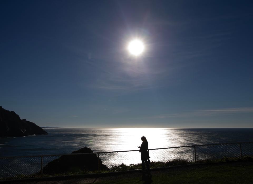 A visitor to the Oregon Coast stands on Heceta Head north of Florence.