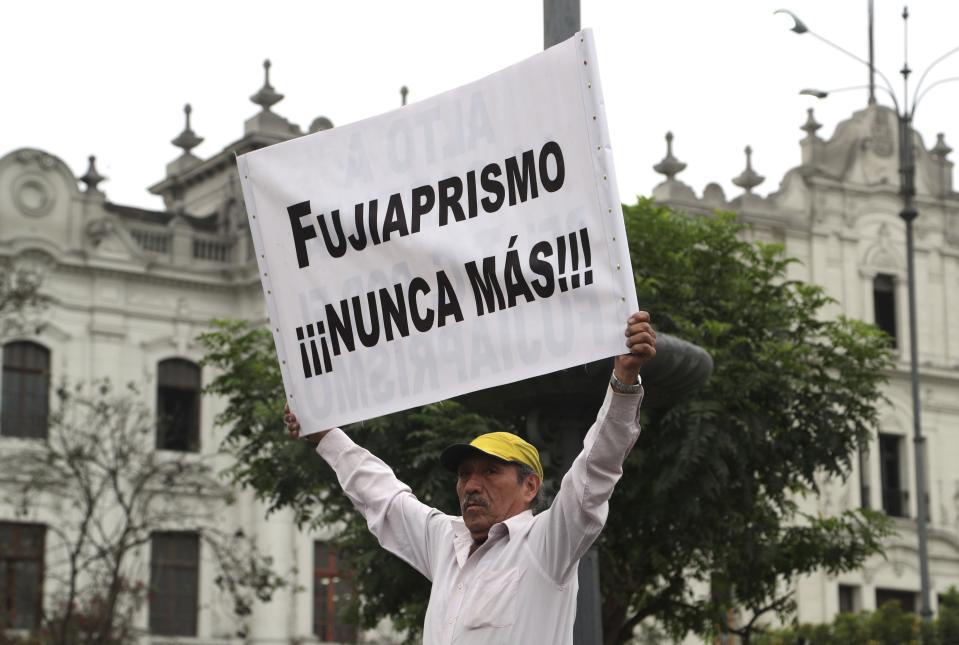 A supporter of Peru's President Martin Vizcarra holds the Spanish message: "Fuji-Aprismo never again!," referring to the Fujimori administration and the opposition political party Apra, during a rally to show support for Vizcarra after he dissolved Congress, near both Congress and the presidential palace in Lima, Peru, Thursday, Oct. 3, 2019. Peru is in the throes of its deepest constitutional crisis in nearly three decades as Vizcarra and the opposition-controlled congress engage in an acrimonious tug of war over who should lead the South American nation. (AP Photo/Martin Mejia)