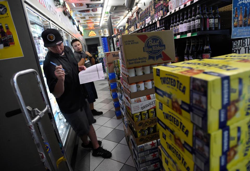 Torieun Jackson, a manager at Liquor Kabinet, goes over a shipment of alcohol as it is delivered to the store in Fort Collins, Colo. on Wednesday, Aug. 12, 2020. Liquor sales have increased, even compared to previous spikes during the pandemic earlier in this year. 