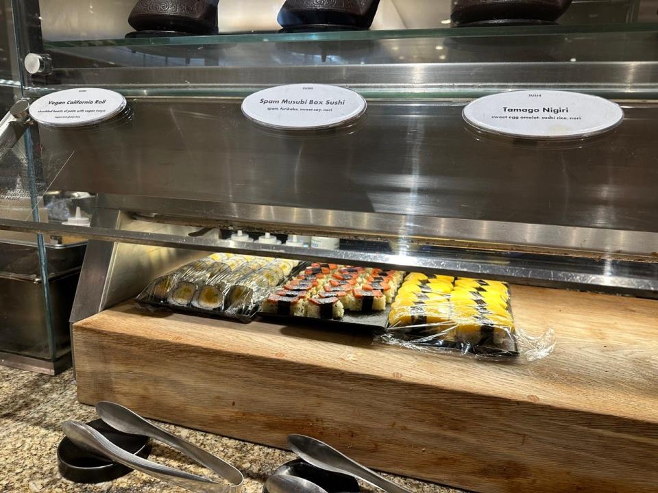 Vegan california roll, spam musubi rolls, and tamago nigiri on a wooden box at Bacchanal buffet