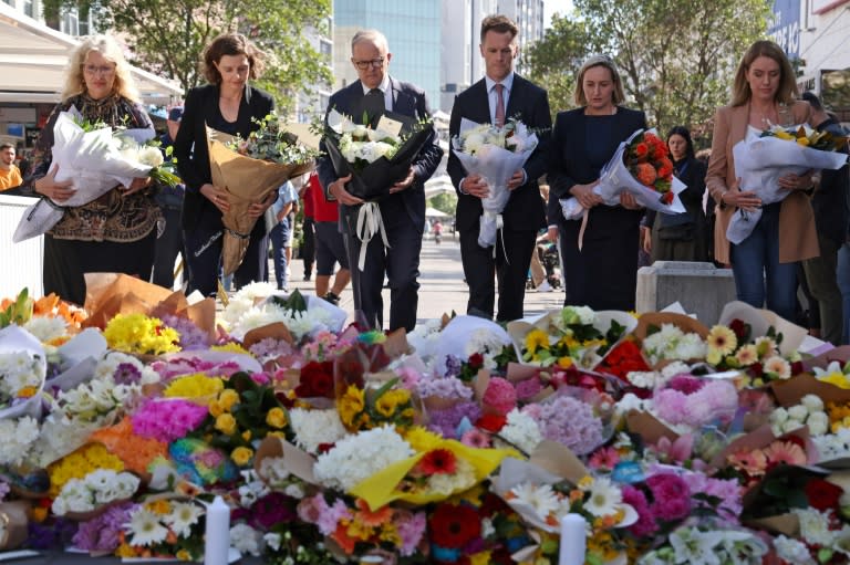 Australian Prime Minister Anthony Albanese (C, with NSW premier Chris Minns) leave flowers in tribute to the victims of the shopping mall attack (DAVID GRAY)