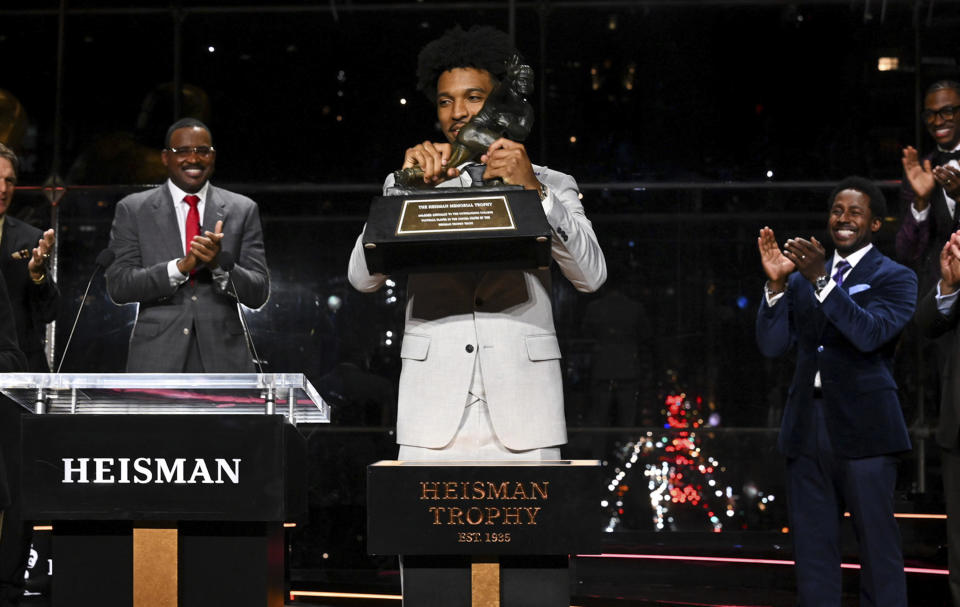 LSU quarterback Jayden Daniels lifts Heisman Trophy after winning the college football award, Saturday, Dec. 9, 2023, in New York. (Todd Van Emst/Pool Photo via AP)