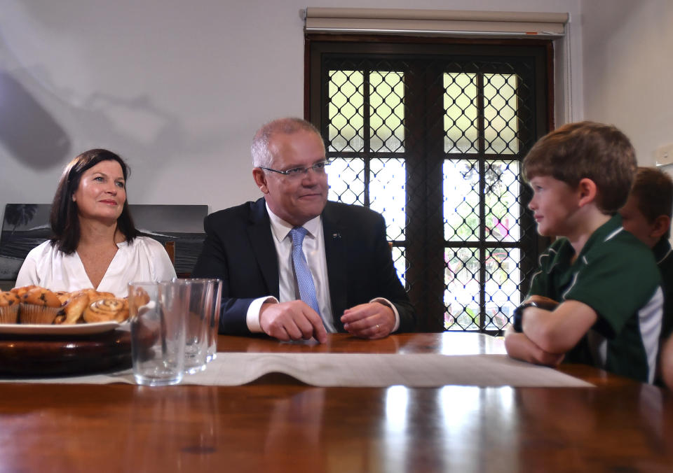 Australian Prime Minister Scott Morrison, center, meets with a family saving for their first home in Cairns, Australia Friday, May 17, 2019. A federal election will be held in Australian on Saturday May 18, 2019. (Mick Tsikas/AAP Image via AP)