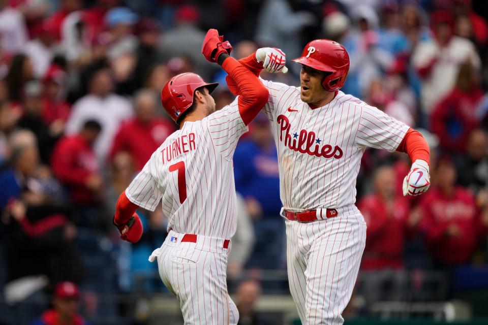 Philadelphia Phillies' J.T. Realmuto, right, celebrates with teammate Trea Turner after hitting a two-run home run off Cincinnati Reds' Derek Law during the seventh inning of a baseball game, Friday, April 7, 2023, in Philadelphia. (AP Photo/Matt Rourke)