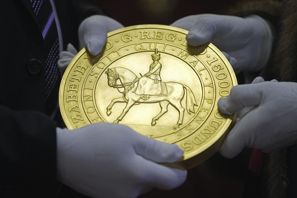 A 15-kilogram (33-pound) gold coin produced to celebrate the late Queen Elizabeth II's Platinum Jubilee, is assessed during the "Trial of the Pyx,'' a ceremony that dates to the 12th Century in which coins are weighed in order to make certain they are up to standard, at the Goldsmiths' Hall in London, Tuesday, Feb. 7, 2023. A jury sat solemnly in a gilded hall in central London on Tuesday, presided over by a bewigged representative of the crown in flowing black robes, but there were no criminals in the dock. (AP Photo/Kin Cheung)