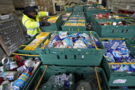 A volunteer from the charity 'The Felix Project' collects food at their storage hub in London, Wednesday, May 4, 2022. Across Britain, food banks and community food hubs that helped struggling families, older people and the homeless during the pandemic are now seeing soaring demand. The cost of food and fuel in the U.K. has risen sharply since late last year, with inflation reaching the highest level in 40 years. (AP Photo/Frank Augstein)