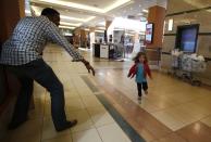 A child runs to safety as armed police hunt gunmen who went on a shooting spree at Westgate shopping center in Nairobi September 21, 2013.(REUTERS/Goran Tomasevic)