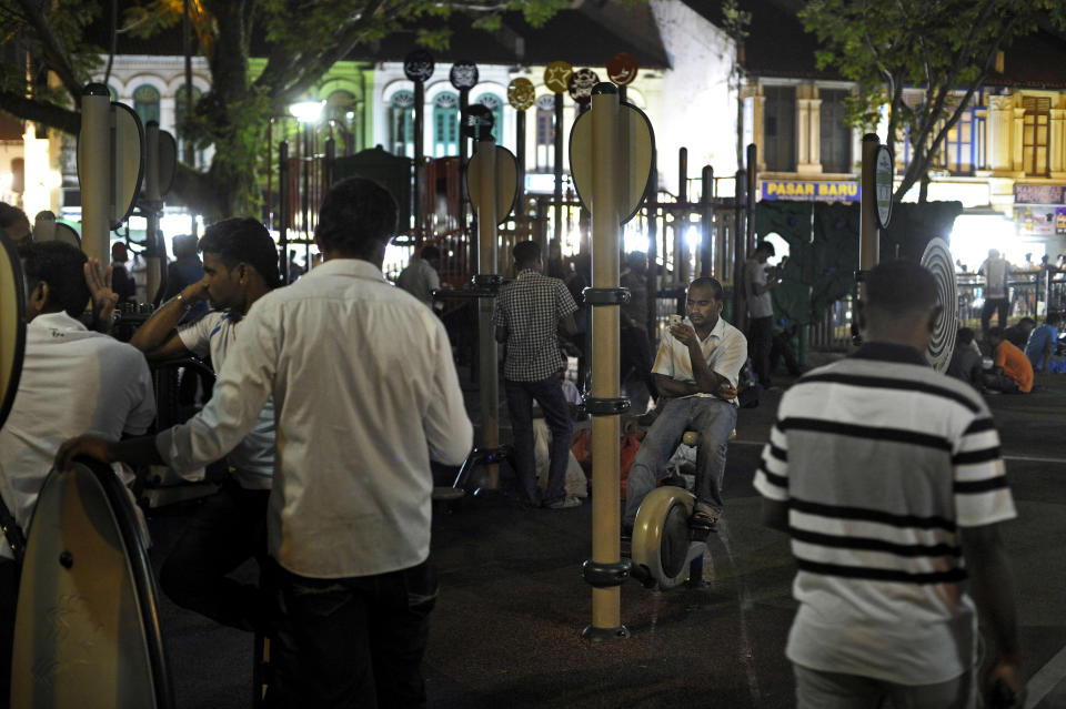 In this photo taken Feb. 9, 2014, migrant workers populate a senior citizens corner and children's playground as they spend their day off in Singapore's Little India District. Singapore’s wealth and continued growth rely in large part on foreign workers. Yet as the numbers of migrant workers soar, tales of abuse and exploitation are threatening to take some of the shine off the city-state’s international reputation. (AP Photo/Joseph Nair)