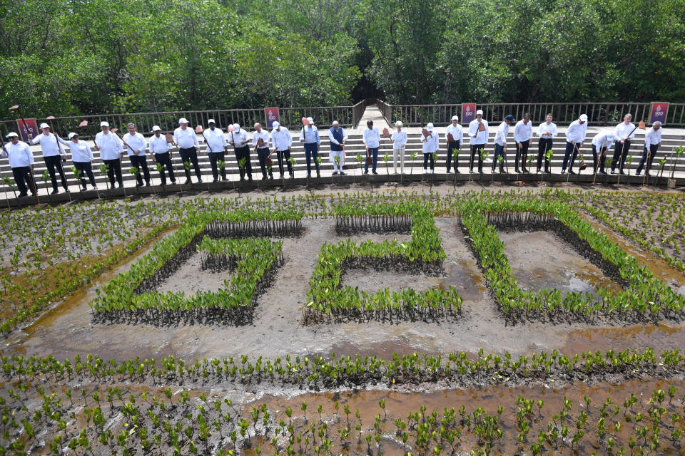 President Joko Widodo with leaders of the G20 and international organisation leaders lift their hoes after planting mangroves at the G20 Indonesia Summit events at the Ngurah Rai Forest Park, Denpasar, Bali, Indonesia, November 16, 2022. Akbar Nugroho Gumay/G20 Media Center/Handout via REUTERS THIS IMAGE HAS BEEN SUPPLIED BY A THIRD PARTY. MANDATORY CREDIT.