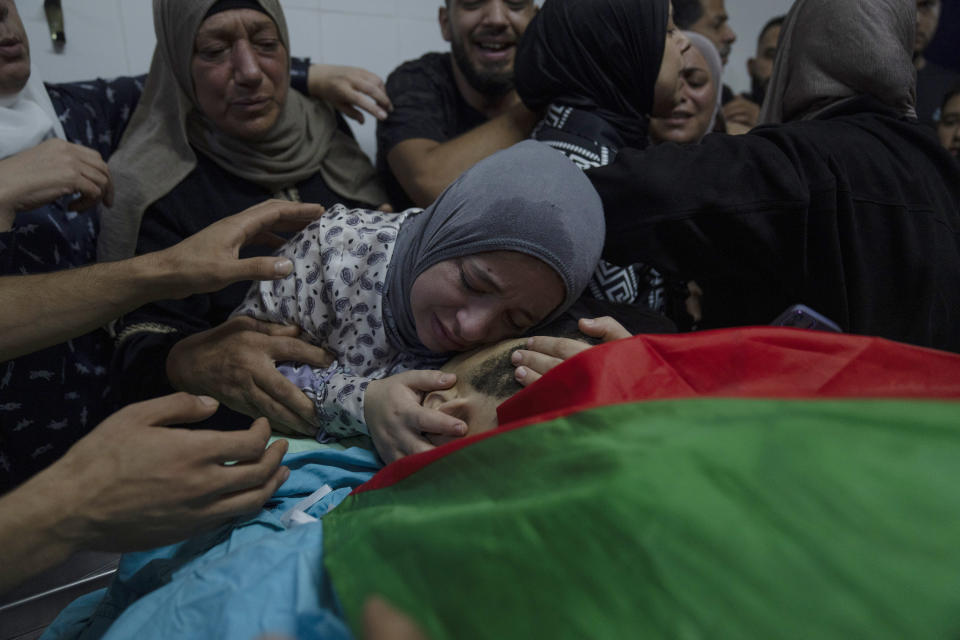 Alaa Jadelhaq, wife of Mohanad Jadelhaq, 29 takes the last look at his body during his funeral in the West Bank city of Ramallah, Thursday, Nov. 9, 2023. Jadelhaq was killed during an Israeli army raid in the occupied West Bank refugee camp of Amari, Palestinian ministry of health said. (AP Photo/Nasser Nasser)