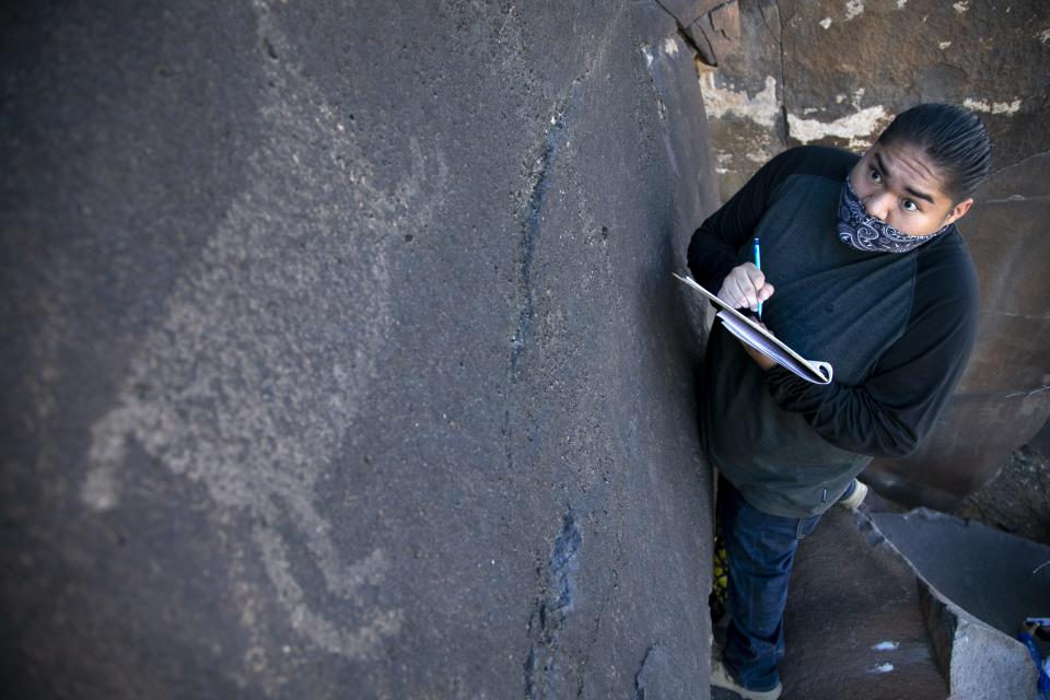 Zion White, a tribal member of the Fort Yuma Quechan Indian Tribe, sketches petroglyphs near the Gila River in an area of Bureau of Land Management public land known as the Great Bend of the Gila on Feb. 3, 2021.