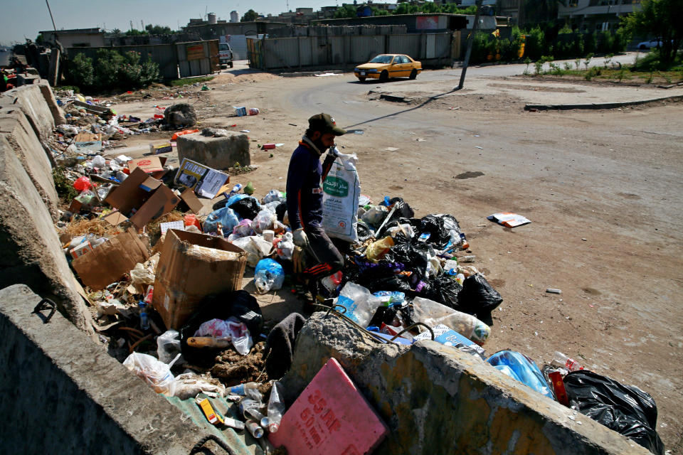 A man searches for recycled items in a landfill in Baghdad, Iraq, Tuesday, Oct. 20, 2020. Iraq is in the throes of an unprecedented liquidity crisis, as the cash-strapped state wrestles to pay public sector salaries and import essential goods while oil prices remain dangerously low. (AP Photo/Khalid Mohammed)