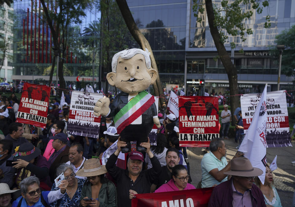 A man holds up a doll of the Mexican President Andres Manuel Lopez Obrador during a march in support of his administration, in Mexico City, Sunday, Nov. 27, 2022.(AP Photo/Fernando Llano)