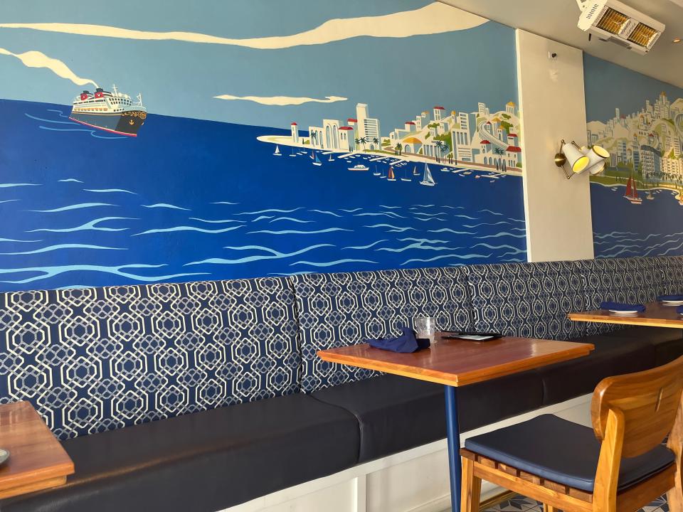 table with colorful mural backdrop at bar riva restaruant in disney's riviera resort