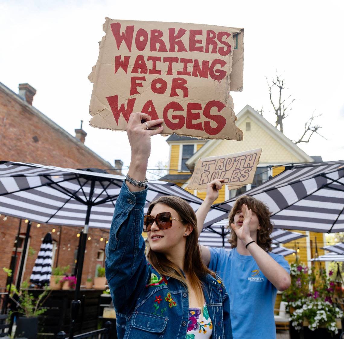 Former employee Ella Hoffhine picketed in front of Apericena on Friday. Hoffhine has sued owner Danielle Christine, seeking damages after she spent months demanding her pay, she said.