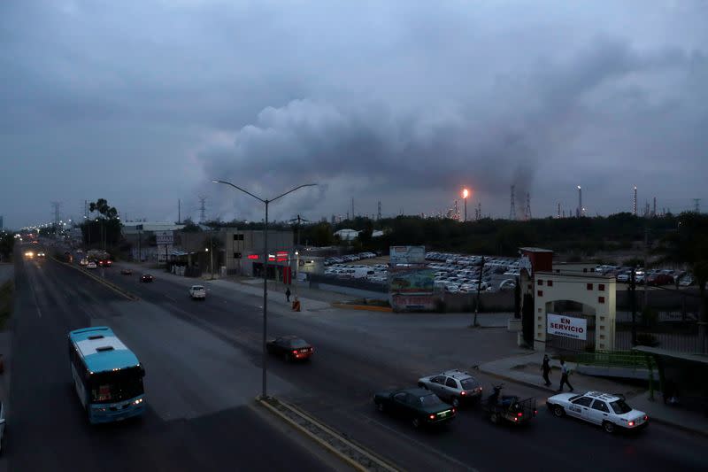 Excess natural gas is burnt, or flared, in the distance from Mexican state-run Pemex's Tula oil refinery as seen from a pedestrian bridge next to the Tula power plant belonging to national power company Commission Federal de Electricidad