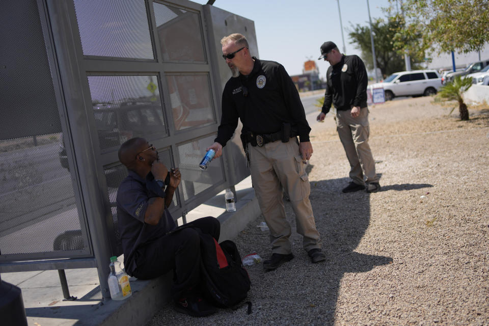 Mark Paulson, a Public Response and Code Enforcement officer, hands out cold water, Wednesday, July 10, 2024, during a heat emergency in Henderson, Nev. (AP Photo/John Locher)