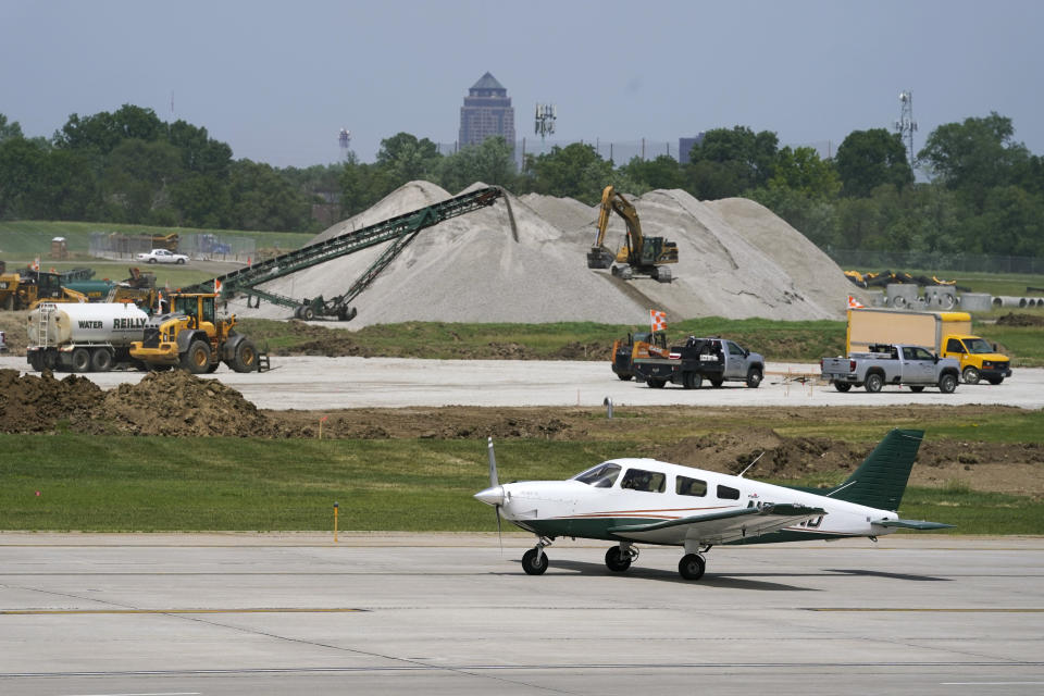 A small plane taxis past construction at the Des Moines International Airport, Monday, June 13, 2022, in Des Moines, Iowa. Officials at the airport were counting on the federal infrastructure money to replace an aging terminal with a modern structure. Four years ago, a new 14-gate terminal was projected to cost about $434 million and be open by 2026. By this spring, the cost had soared to $733 million. (AP Photo/Charlie Neibergall)