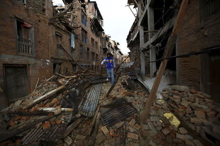 A man walks along the collapsed houses after the earthquake in Bhaktapur, Nepal April 27, 2015. REUTERS/Navesh Chitrakar