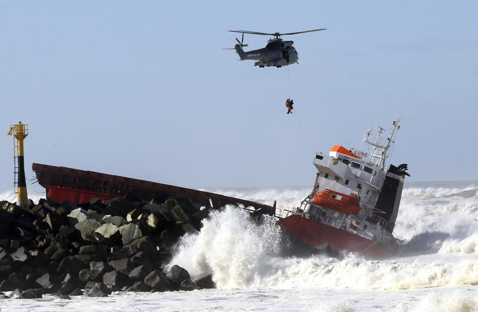 A sailor is lifted off by a military helicopter after a Spanish cargo ship that slammed into a jetty in choppy Atlantic Ocean waters off Anglet, southwestern France, Wednesday, Feb. 5, 2014. The hold of the ship, the Luno, was empty when the accident occurred along the coast of the town of Anglet, and a small amount of fuel was spilling into the water, officials said. The ship had been heading to a nearby port to load up with cargo when its engine conked out and the rough waves carried it into the jetty. (AP Photo/Bob Edme)