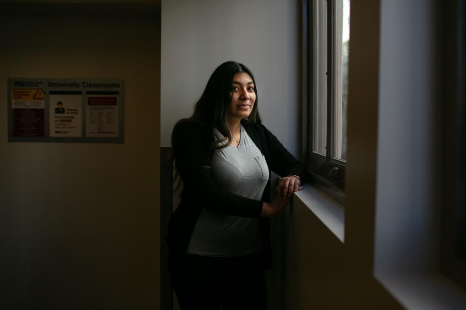 A woman standing near a window