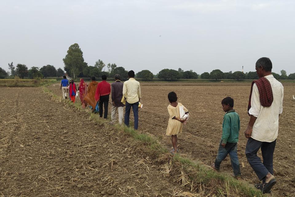 A migrant family walks back home in the evening after harvesting millet crop in a farm in Nanu village in Uttar Pradesh state, India, on Oct. 17, 2023 As the annual U.N.-led climate summit known as COP is set to convene later this month in Abu Dhabi, experts are urging policymakers to respond to climate change’s disproportionate impact on women and girls, especially where poverty makes them more vulnerable. (Uzmi Athar/Press Trust of India via AP)