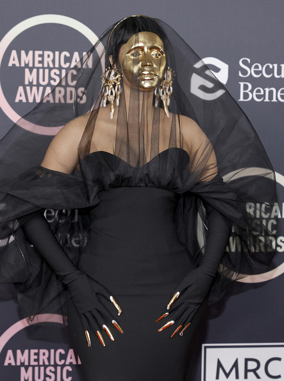 Cardi B wears a black dress and gold face mask at the 2021 American Music Awards at Microsoft Theater on November 21, 2021 in Los Angeles, California