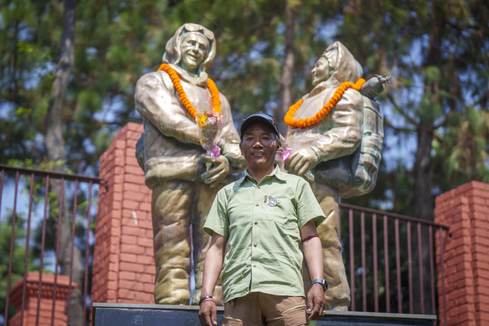 Record holder Veteran Sherpa guide Kami Rita poses for a photo in front of the statues of New Zealander Edmund Hillary, left, and his Sherpa guide Tenzing Norgay on the 70 anniversary of the first ascent of Mount Everest in Kathmandu, Nepal, Monday, May 29, 2023. The 8,849-meter (29,032-foot) mountain peak was first scaled by Hillary and Norgay on May 29, 1953. (AP Photo/Niranjan Shrestha)