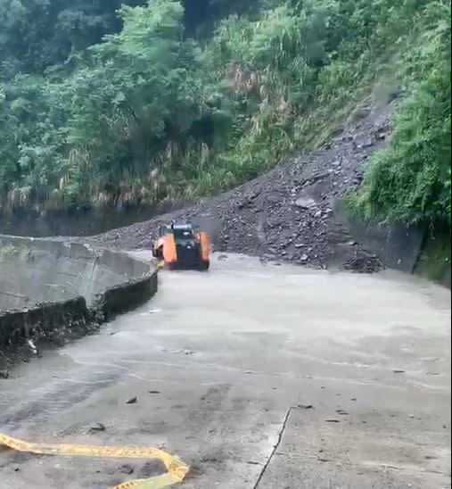 雨彈狂炸南投，山上土石鬆落傾瀉而下阻斷道路，出動大型機具搶通。（圖／翻攝畫面）