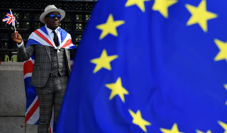 A pro-Brexit protester stands behind an EU flag ahead of the forthcoming EU elections, outside of the Houses of Parliament in London, Britain, May 22, 2019. REUTERS/Toby Melville