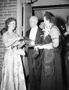 Shirley Temple, left, of the movies, hands a program to Secretary of the Treasury John W. Snyder and his wife Carrie Evelyn Snyder as they arrive for President Truman's inaugural ball in Washington, Jan. 20, 1949. (AP Photo)