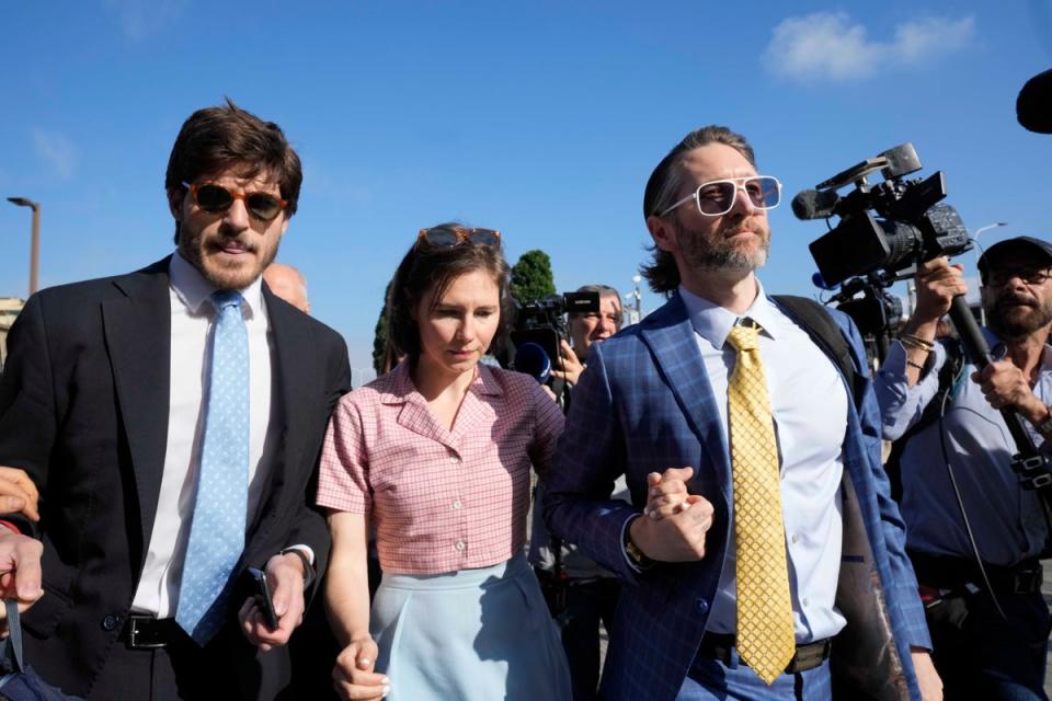 Knox arrives flanked by her husband Christopher Robinson, right, and her lawyer Luca Luparia Donati (AP)