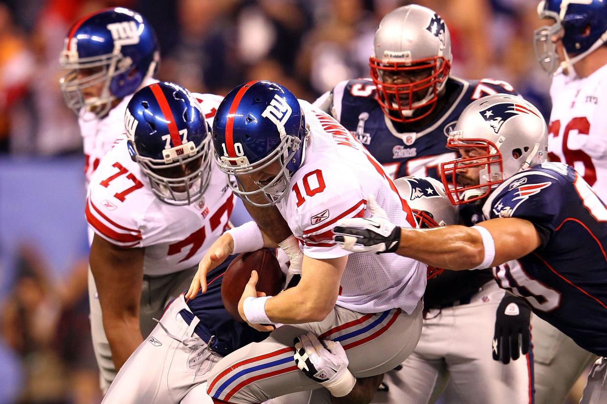 Defensive end Mark Anderson #95 of the New England Patriots sacks Eli Manning #10 of the New York Giants in the first quarter during Super Bowl XLVI at Lucas Oil Stadium on February 5, 2012