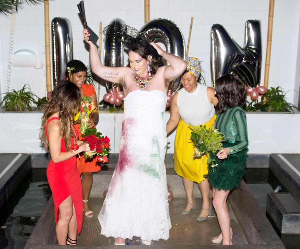 Inside each of the bridesmaids' bouquets were hidden spray-paint cans. Following the vows, the bridal party tore off Diane's black train and spray-painted their gown rainbow colors to symbolize Pride. (Photo: <a href="http://www.elyssamaxxgoodman.com/" target="_blank">Elyssa Goodman</a>)