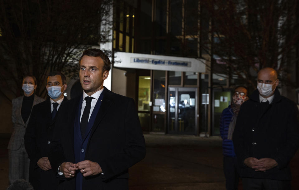 French President Emmanuel Macron, flanked by French Interior Minister Gerald Darmanin, second left, and French Education Minister Jean-Michel Blanquer, right, speaks in front of a high school Friday Oct.16, 2020 in Conflans Sainte-Honorine, northwest of Paris, after a history teacher who opened a discussion with high school students on caricatures of Islam's Prophet Muhammad was beheaded. French President Emmanuel Macron denounced what he called an "Islamist terrorist attack" against a history teacher decapitated in a Paris suburb Friday, urging the nation to stand united against extremism. (Abdulmonam Eassa, Pool via AP)