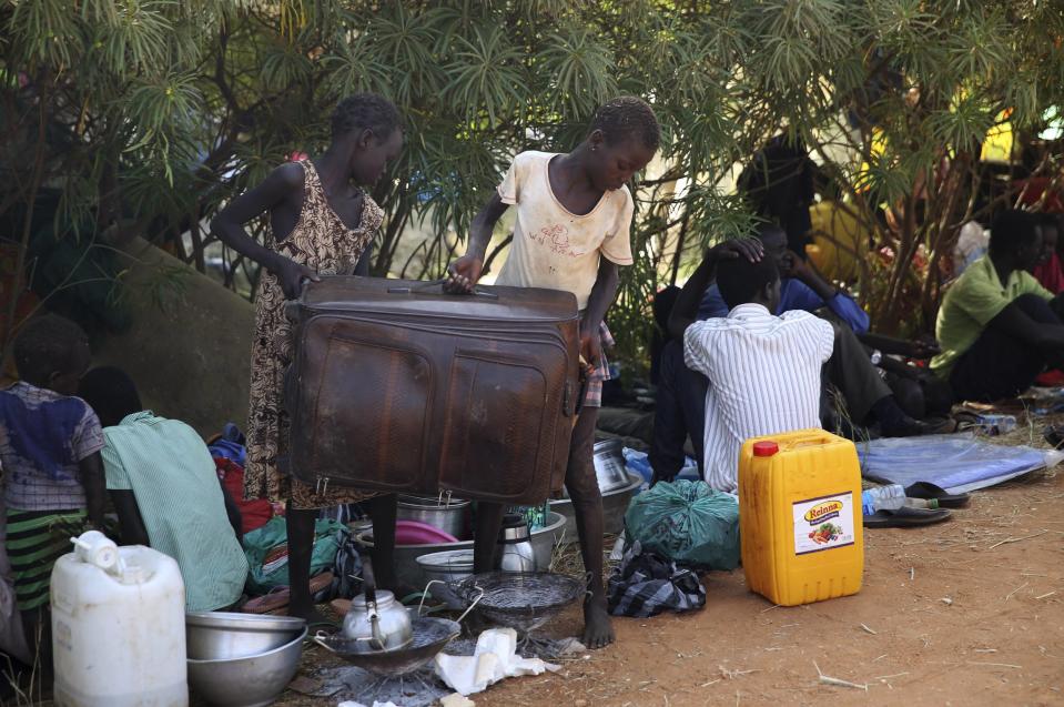 Internally displaced children carry a bag sit inside a UNMIS compound in Juba