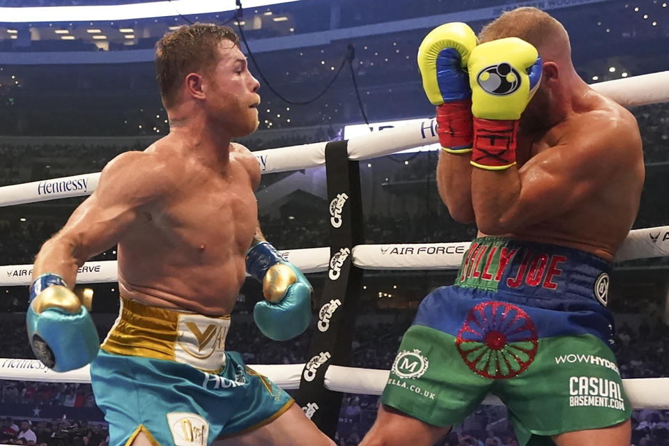 Canelo Alvarez, left, throws a punch against Billy Joe Saunders during a unified super middleweight world championship boxing match, Saturday, May 8, 2021, in Arlington, Texas.(AP Photo/Jeffrey McWhorter)