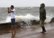 <p>Julie Plaisance, right, and Renee Davila take photos on the shore of Lake Pontchartrain as weather from Tropical Storm Cindy, in the Gulf of Mexico, impacts the region in New Orleans, June 20, 2017. (Photo: Gerald Herbert/AP) </p>