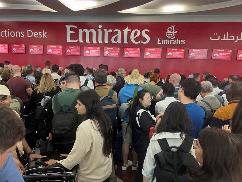 FILE PHOTO: People queue at a flight connection desk after a rainstorm hit Dubai, causing delays at the Dubai International Airport