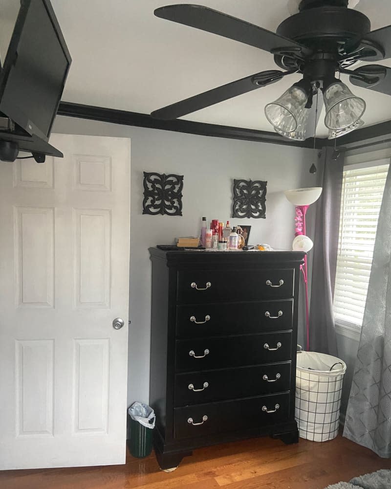 Black dresser in bedroom before renovation.