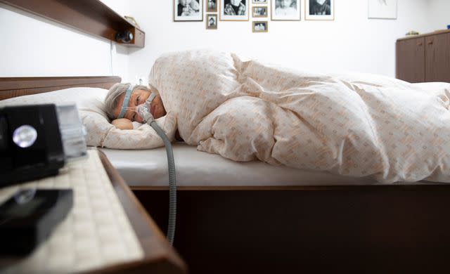 <p> Ute Grabowsky/Photothek via Getty</p> Person using a device for sleep apnea.