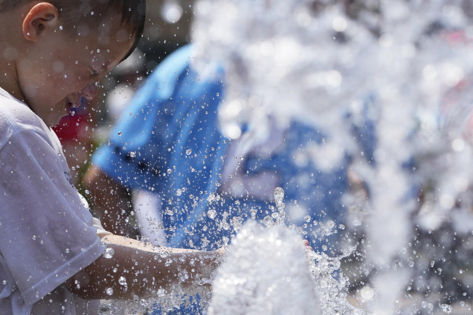 A boy cools off at a fountain during hot weather in Chicago, Sunday, June 16, 2024. (AP Photo/Nam Y. Huh)