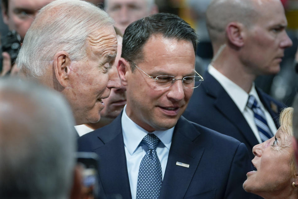 FILE— In this July 28, 2021 file photo Pennsylvania Attorney General Josh Shapiro, center, and President Joe Biden talk with people at the Lehigh Valley operations facility for Mack Trucks in Macungie, Pa. The high-profile attorney general will formally announce his candidacy for governor of Pennsylvania on Wednesday, Oct. 13, 2021, entering the 2022 race. (AP Photo/Susan Walsh, File)