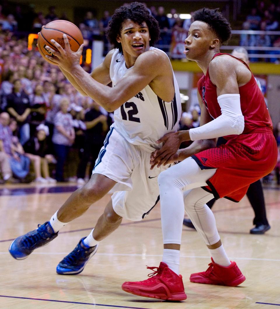 Evansville Reitz High School's Dru Smith (12) drives around New Albany's Romeo Langford to score during their 4A regional championship game March 12, 2016, in Seymour, Ind.