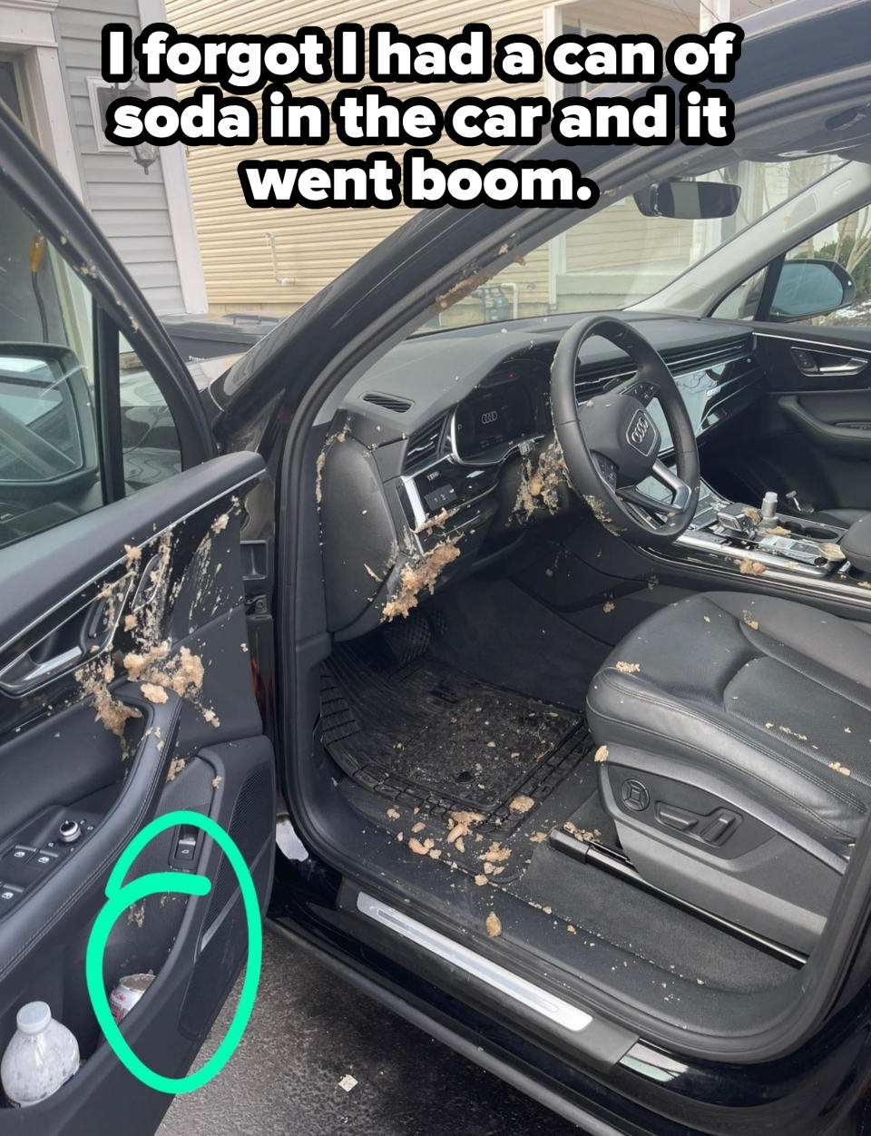 A car interior with soda spattered all over the front seat, driver's side, steering wheel, and door