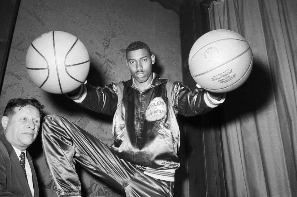 Wilt "The Stilt" Chamberlain, twice All-American at the University of Kansas, bedazzles Harlem Globetrotters' boss Abe Saperstein with his basketball-palming technique on June 18, 1959.