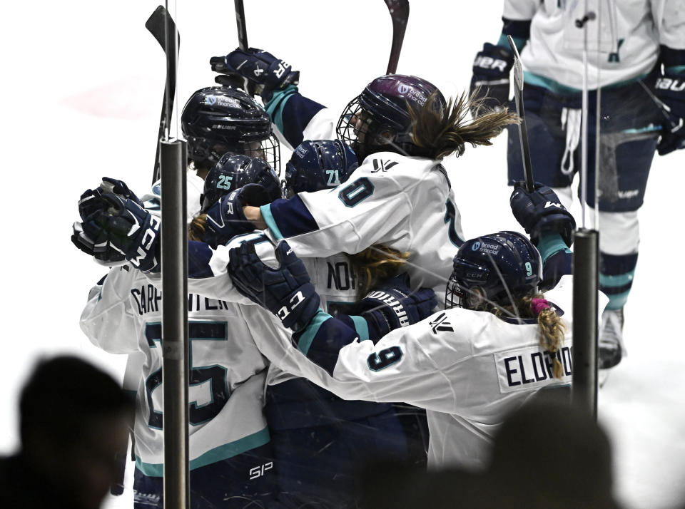 New York's Kayla Vespa (10) leaps onto teammates as they celebrate after the winning goal by Alex Carpenter (25) in overtime PWHL hockey game action against Ottawa in Ottawa, Ontario, Sunday, Feb. 4, 2024. (Justin Tang/The Canadian Press via AP)